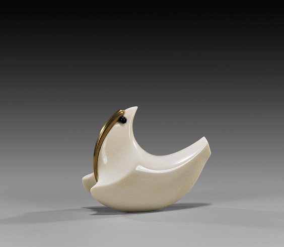 CONTEMPORARY IVORY NETSUKE: Bird: CONTEMPORARY IVORY NETSUKE: Bird Beautifully polished, contemporary carved ivory netsuke; of a stylized bird, in a sweeping pose, mounted with a crest of yellow gold and with black inlaid eyes; by Geo