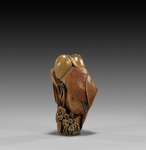 CONTEMPORARY WOOD NETSUKE: Still Life: CONTEMPORARY WOOD NETSUKE: Still Life Contemporary carved and lacquered wood netsuke; of an armature supporting two sets of cloaks and hats, tied together with rope and with flowers growing at the bas