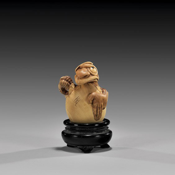 CONTEMPORARY WOOD NETSUKE: Tengu: CONTEMPORARY WOOD NETSUKE: Tengu Charming contemporary carved wood netsuke; of a baby karasu tengu breaking out of its egg; by Nick Lamb (British, b. 1948), signed; wood stand
