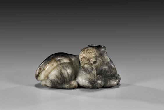 CARVED GRAY & BLACK JADE QILIN: CARVED GRAY & BLACK JADE QILIN Chinese carved greenish-gray and black jade model of a wise old qilin with long beard: in a recumbent position with his head turned back; possibly Yuan/Ming Dynasty; L: 