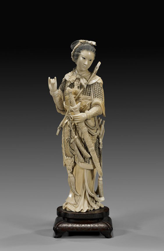 ANTIQUE CARVED IVORY WARRIOR BEAUTY: ANTIQUE CARVED IVORY WARRIOR BEAUTY Superbly carved, antique Chinese ivory figure; of a warrior beauty in finely detailed chain-maille armor, with pendants and tassels, holding a large sword to the fr
