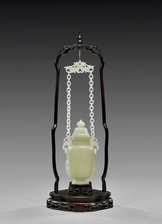CHINESE CARVED CELADON JADE CHAIN VASE: CHINESE CARVED CELADON JADE CHAIN VASEFine Chinese carved celadon jade chain vase with cover: of flattened urn form, with small foliate flanges, the cover with peach form knop; the shoulders pending l