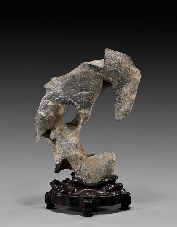 CHINESE TAIHU SCHOLAR'S ROCK: CHINESE TAIHU SCHOLAR'S ROCKChinese Taihu stone "scholar's rock"; the limestone with rivering throughout the gray to tan body; of a dramatic 'C' formation with a strong jutting hook and an opening at