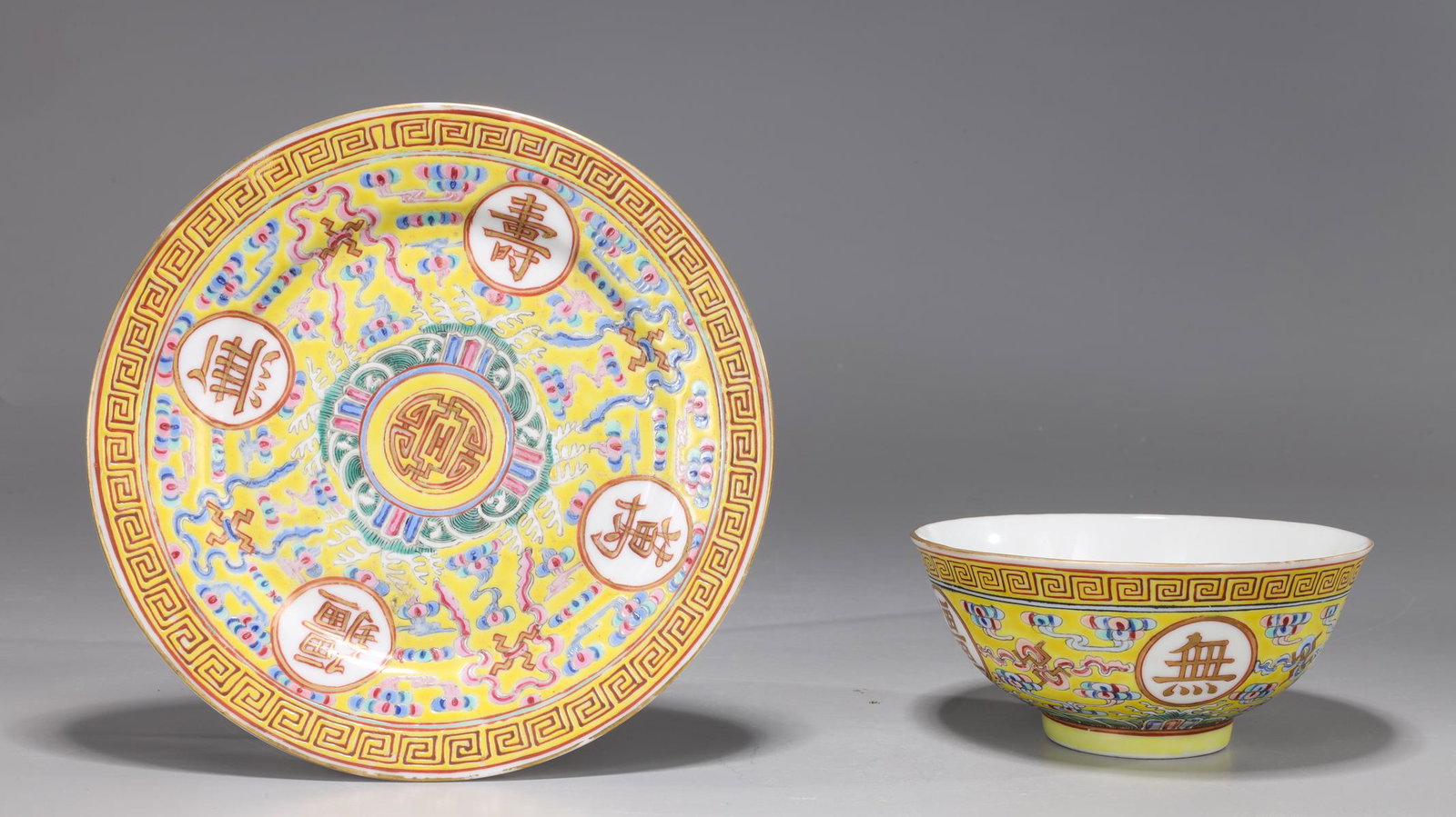Chinese Guangxu Period Enamel Porcelain Bowl and Saucer: Antique Chinese Guangxu period enameled porcelain wedding bowl and saucer on imperial yellow ground; the interior with central shou character surrounded by bats; the exterior finely decorated with key