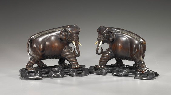 Pair Old Chinese Carved Wood Elephants: Pair Old Chinese Carved Wood Elephants Pair, early 20th Century Chinese carved wood elephants: each in a walking stance and with ivory tusks, inlaid eyes to each (chips to tusks); L: 8" (each), openwo