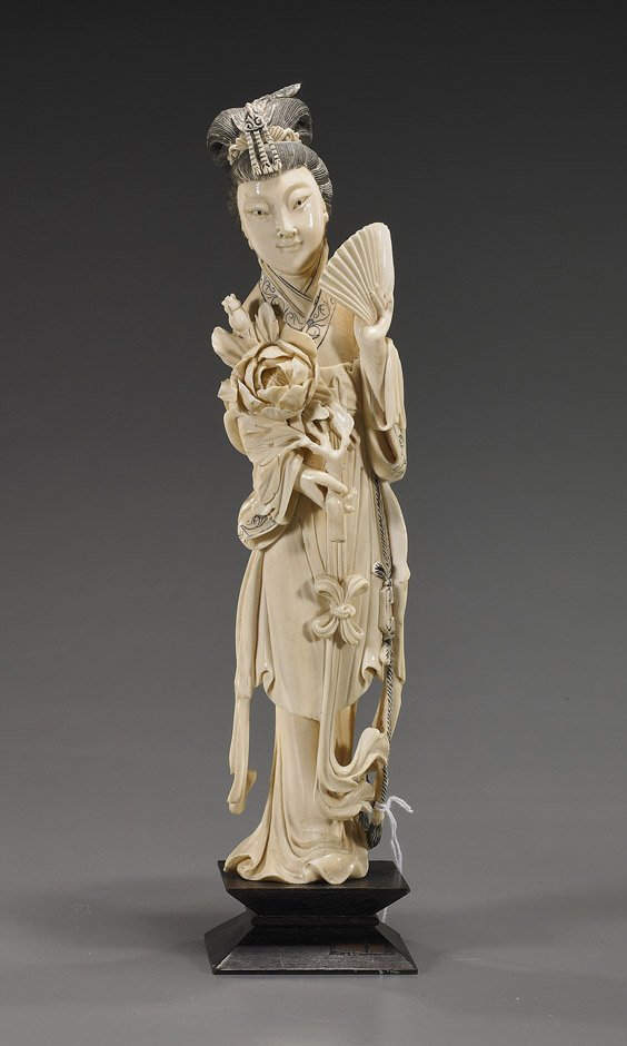 Chinese Carved Ivory Standing Beauty: Chinese Carved Ivory Standing BeautyChinese carved ivory beauty; standing in long robes and wearing a phoenix headdress; carrying a fan in one hand, a flower branch in the other, some inked incised de