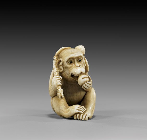 CARVED IVORY NETSUKE: Monkey & Peach: 象牙根付 CARVED IVORY NETSUKE: Monkey & Peach Amusing early 20th Century carved ivory netsuke; of a seated monkey eating a peach and holding a branch of peaches over his should
