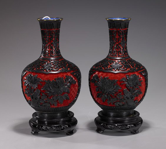 Pair Chinese Carved Cinnabar Lacquer Vases: Pair Chinese Carved Cinnabar Lacquer VasesPair Chinese 2-color carved cinnabar lacquer vases; each bottle form with black on red floral panel-type designs and floral grounds; H: 8 1/4" (each), wood st