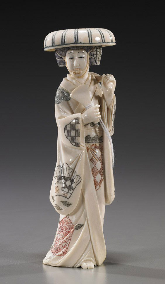 Carved Ivory Okimono: Beauty with Fan: Carved Ivory Okimono: Beauty with FanCarved ivory okimono of a beauty; standing in long robes and with a hat: holding a leafy branch over one shoulder and a tool or tablet in the other hand; some ligh
