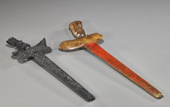 Two Old Indonesian Kris: Two Old Indonesian (Kris) Swords Two old Indonesian kris; each with wood sheath: one with slightly curved blade and carved handle, one side of the sheath lacquered; the other with undulating blade and