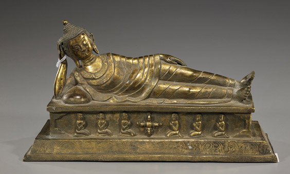 Sino-Tibetan / Southeast Asian Gilt Bronze Buddha: Sino-Tibetan / Southeast Asian Gilt Bronze Buddha Sino-Tibetan or Southeast Asian gilt bronze model of a reclining Buddha: wearing long robes and with snail-curl hair, on a rectangular base cast with 