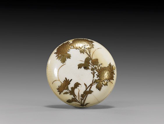 SMALL ANTIQUE IVORY MANJU NETSUKE: 象牙饅頭根付 SMALL ANTIQUE IVORY MANJU NETSUKE Antique ivory manju netsuke; of somewhat diminutive size, with design of gold lacquer blossoms, late 19th Century; un