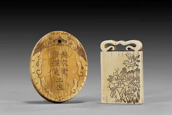 TWO CHINESE CARVED IVORY PENDANTS: 象牙吊墜 兩件 TWO CHINESE CARVED IVORY PENDANTSTwo Chinese ivory pendants: of oval form, with calligraphy framed by stylized dragons, with fine patina; together wit