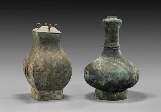 TWO HAN DYNASTY ARCHAIC BRONZES: 漢 青銅器 兩件 TWO HAN DYNASTY ARCHAIC BRONZES Two archaic, Chinese Han Dynasty bronzes, both heavily patinated: bottle form vase with garlic mouth; together with s
