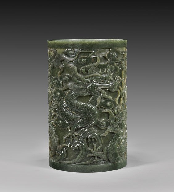 CHINESE CARVED SPINACH JADE BRUSHPOT: 碧玉雕祥龍趕珠筆筒 CHINESE CARVED SPINACH JADE BRUSHPOT Tall and very elaborately carved, Chinese spinach jade brushpot: of cylindrical form, with