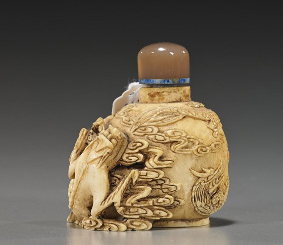 Chinese Carved Ivory Snuff Bottle: Chinese Carved Ivory Snuff Bottle Unusual, very elaborately carved and well hollowed, Chinese ivory snuff bottle; with various writhing dragons in relief among clouds and with a carnelian agate "jewel