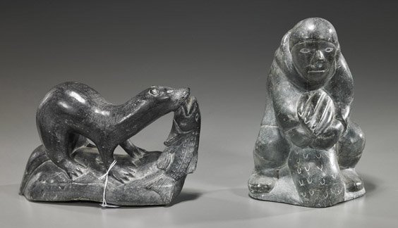 Two Eskimo Carved Soapstone Sculptures: Two Eskimo Carved Soapstone Sculptures Two Eskimo carved grey soapstone sculptures: one of an otter with a fish in its mouth; the other of a standing figure holding fish; original Canadian labels on b