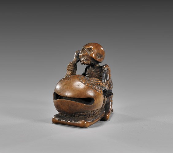 ANTIQUE WOOD NETSUKE: Skeleton & Bell: 木製根付 ANTIQUE WOOD NETSUKE: Skeleton & Bell Unusual and finely detailed, antique carved wood netsuke: of a skeleton beating a large mokugyo bell; unsigned; early 19th Centur