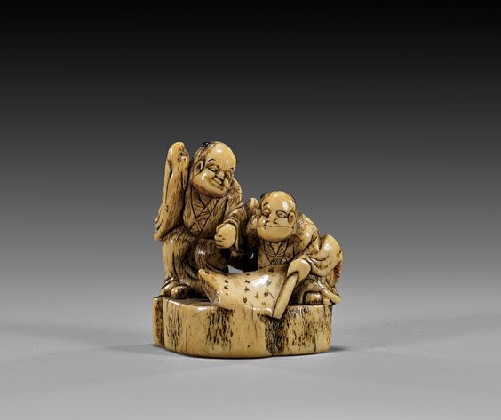 ANTIQUE IVORY FIGURAL NETSUKE: 象牙人物根付 ANTIQUE IVORY FIGURAL NETSUKE Antique and finely patinated, carved ivory netsuke; of two figures, one standing and one seated, together inspecting a sc