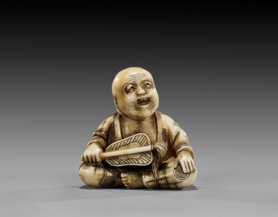 ANTIQUE JEWELED IVORY NETSUKE: Sennin: 象牙人物根付 ANTIQUE JEWELED IVORY NETSUKE: Sennin Antique carved ivory figural netsuke; of a sennin seated and holding a fan, the back of his robes unusually 'jewe