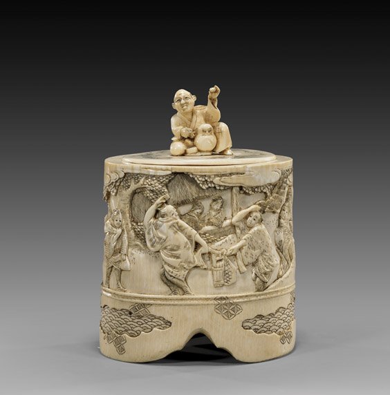 ANTIQUE JAPANESE CARVED IVORY BOX: 象牙雕人物紋圓蓋盒 ANTIQUE JAPANESE CARVED IVORY BOX Finely carved antique Japanese ivory box and cover: the body with relief scene of figures in 
