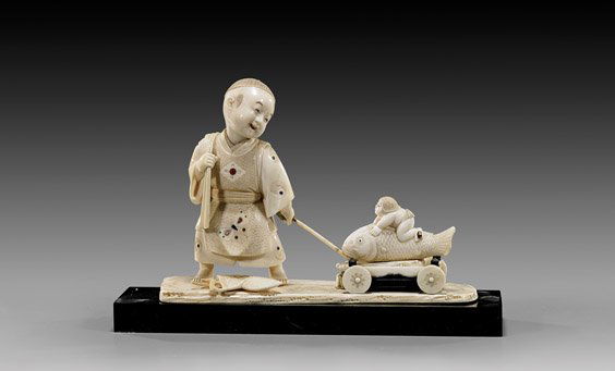 ANTIQUE IVORY OKIMONO: Boy with Toy: 象牙雕孩童拉玩具車擺件 ANTIQUE IVORY OKIMONO: Boy with ToyVery finely carved, antique Japanese sectional ivory okimono; of a boy pulli