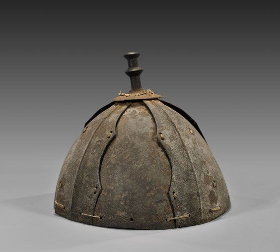 UNUSUAL CHINESE IRON HELMET: 中式鐵頭盔 UNUSUAL CHINESE SECTIONAL IRON HELMETChinese iron helmet; of tall domed form and of sectional construction with leather ties, and a tall, ringed finial; D: 9 1