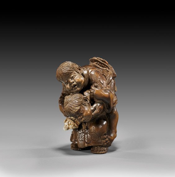 CARVED WOOD NETSUKE: Two Children: 木製根付 孩童 CARVED WOOD NETSUKE: Two Children Very finely carved wood netsuke; by Seiho; depicting one child giving a piggy-back ride to another child, with an iv