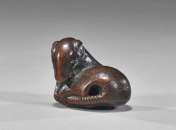 Antique Carved Wood Netsuke: Rat: Antique Carved Wood Netsuke: Rat Antique carved wood Nagoya School netsuke; of a recumbent rat gripping its tail, inlaid eyes (some wear), 19th Century