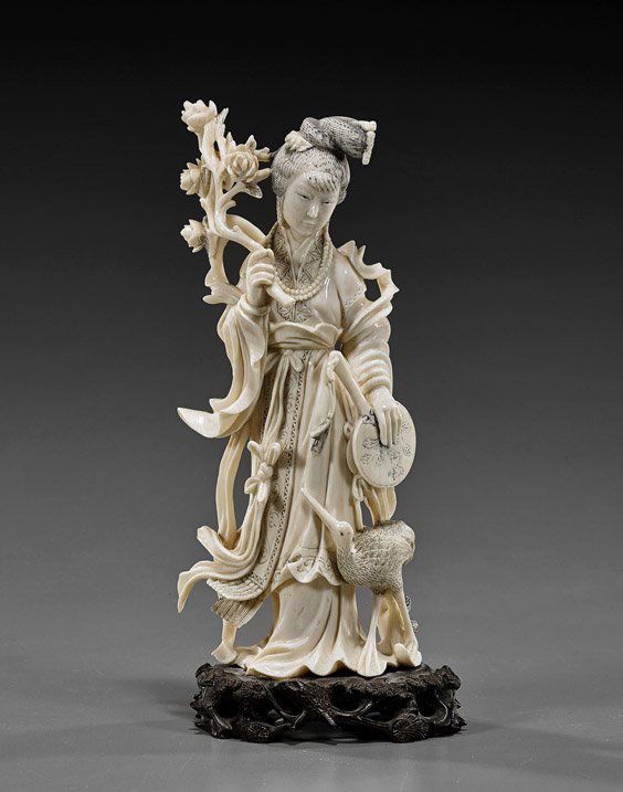 Chinese Carved Ivory Standing Beauty: Chinese Carved Ivory Standing BeautyChinese carved ivory beauty; standing in long flowing robes and carrying a flowering branch in one hand, a fan in the other, and with a crane standing at her feet;