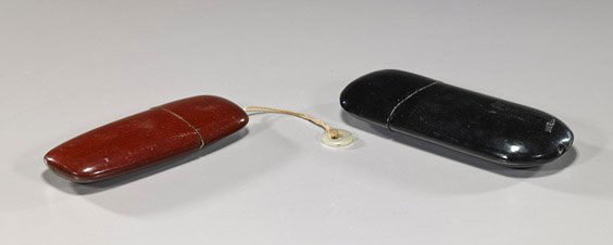 Two Chinese Lacquer Eyeglass Cases: Two Chinese Lacquer Eyeglass CasesTwo antique Chinese lacquer eyeglass cases; each of somewhat flattened ovoid form: the larger black, the smaller reddish brown (small flaws) the small with translucen
