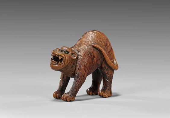 ANTIQUE WOOD NETSUKE: Tiger: 木製根付 ANTIQUE WOOD NETSUKE: Tiger Boldly carved, antique wood netsuke; of an arched snarling tiger, with double inlaid eyes, unsigned; late 19th Century