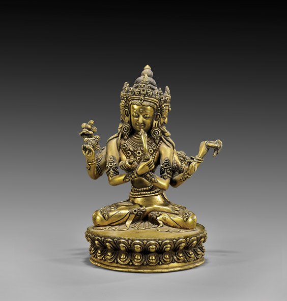 SINO-TIBETAN GILT BRONZE DEITY: 銅鎏金雕菩薩坐像 SINO-TIBETAN GILT BRONZE DEITY Elaborately cast, Sino-Tibetan gilt bronze multi-armed and multi headed Buddhist deity; wearing an ornat
