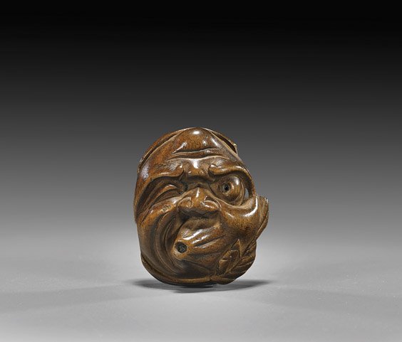 Antique Carved Wood Netsuke: Mask: Antique Carved Wood Netsuke: Mask Antique carved wood mask netsuke; of Hyottoko, with typical different eye size and blowing one way; signed Sanenobu (usual minor wear), 19th Century