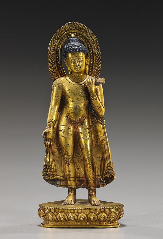 Nepalese or Tibetan Bronze Buddha: Nepalese or Tibetan Bronze Buddha Finely cast, 17th Century-style Nepalese or Tibetan gilt and patinated, coppery bronze figure of a standing Buddha; on lotus pedestal and wearing a cape, one hand in 
