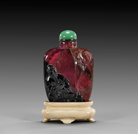 FINE TOURMALINE SNUFF BOTTLE: FINE TOURMALINE SNUFF BOTTLE Rare and finely hollowed, antique and nearly transparent deep red/purple tourmaline snuff bottle; of flattened form: the front with cameo carved design of a sage with cens