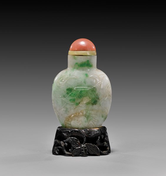 ANTIQUE CARVED JADEITE SNUFF BOTTLE: ANTIQUE JADEITE SNUFF BOTTLE Antique carved jadeite snuff bottle; of spade form, with design of carp in light relief; the white to light green stone with translucent apple green spotting, coral-glass 