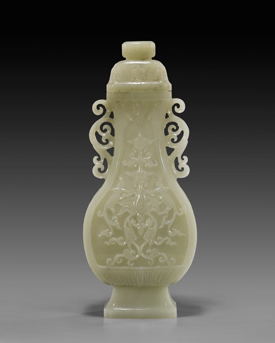 CHINESE CARVED CELADON JADE VASE: CHINESE CARVED CELADON JADE VASE Finely hollowed, Chinese carved celadon jade footed vase; of somewhat flattened baluster form, with openwork scrolling flange handles: the front and verso with stylize
