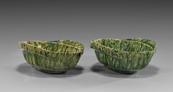 RARE PAIR HAN DYNASTY POTTERY "EAR CUPS": RARE PAIR HAN DYNASTY GLAZED "EAR CUPS" Rare pair of Chinese Han Dynasty, glazed pottery "ear cups"; of unusual size, each displaying fine "watermelon rind" mottled green coloration; L: 5 5/8" (each);