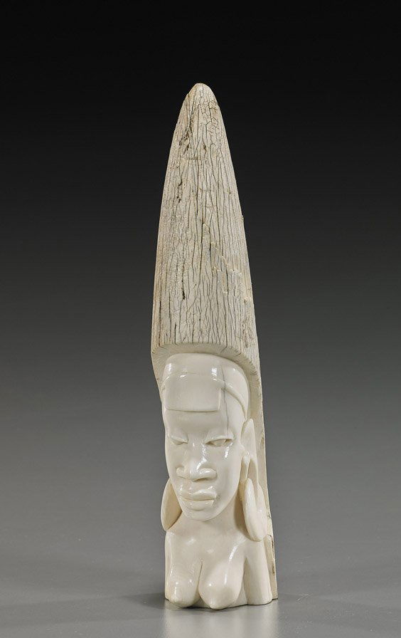 Old African Carved Ivory Tusk Tip: Old African Carved Ivory Tusk TipOld African carved ivory tusk tip; with the nude bust of a woman wearing large earrings (some flaking to ivory exterior); H: 9 1/2"; Provenance: brought to the U.S. by