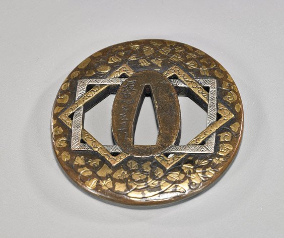 Antique Japanese Inlaid Bronze Tsuba: Antique Japanese Inlaid Bronze Tsuba Antique Japanese bronze tsuba; with unusual geometric central design and with soft metal inlays front and back, signed (some wear); L: 2 3/4"