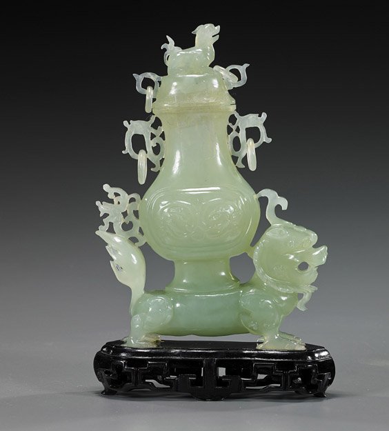 Chinese Carved Translucent Bowenite Urn: Chinese Carved Translucent Bowenite Urn Chinese carved translucent bowenite urn and cover; the vessel on the back of a standing qilin, with mask motifs in relief and four loose rings, qilin finial to 