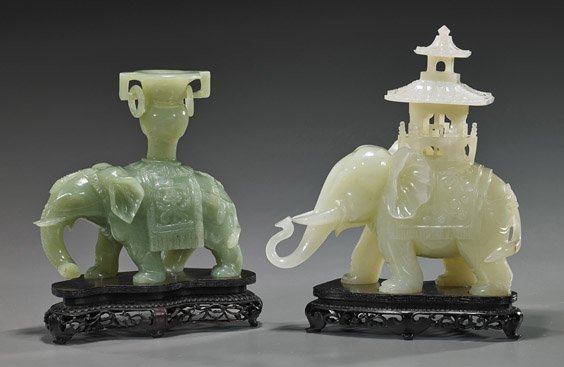 Two Chinese Carved Bowenite Elephants: Two Chinese Carved Bowenite Elephants Two Chinese carved translucent bowenite models of elephants: greenish color, in walking stance and with a caparison and vase on its back, two loose rings; togethe