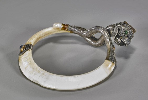Antique Southeast Asian Boar's Tusk Cuff: Antique Southeast Asian Boar's Tusk Cuff Very unusual antique, Southeast Asian or Indonesian, bracelet or arm cuff; consisting of a boar's tusk (chips to ivory), silver mounted with dragon or serpent 