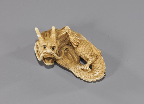 Carved Ivory Netsuke: Coiled Dragon: Carved Ivory Netsuke: Coiled Dragon Carved and lightly stained ivory netsuke; of a somewhat coiled dragon, good detail and inlaid eyes, signed