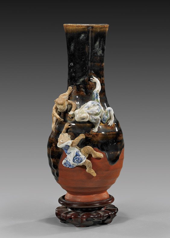 Japanese Sumidagawa Glazed Vase: Japanese Sumidagawa Glazed Vase Old Japanese Sumidagawa ware glazed vase; of bottle form with amusing moulded frog and monkeys, one monkey wearing a blue and white jacket, Circa 1900; H: 10 1/4", wood