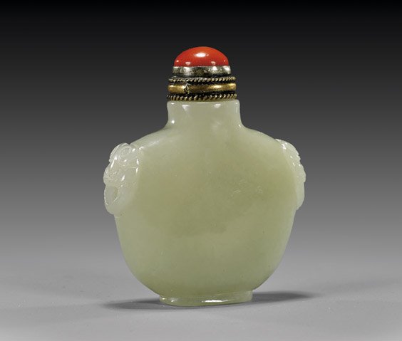 CARVED CELADON JADE SNUFF BOTTLE: CARVED CELADON JADE SNUFF BOTTLEFinely hollowed and carved, celadon jade snuff bottle; of wide flattened urn form, with stylized ogre mask faux ring handles in relief and of even coloration; with meta