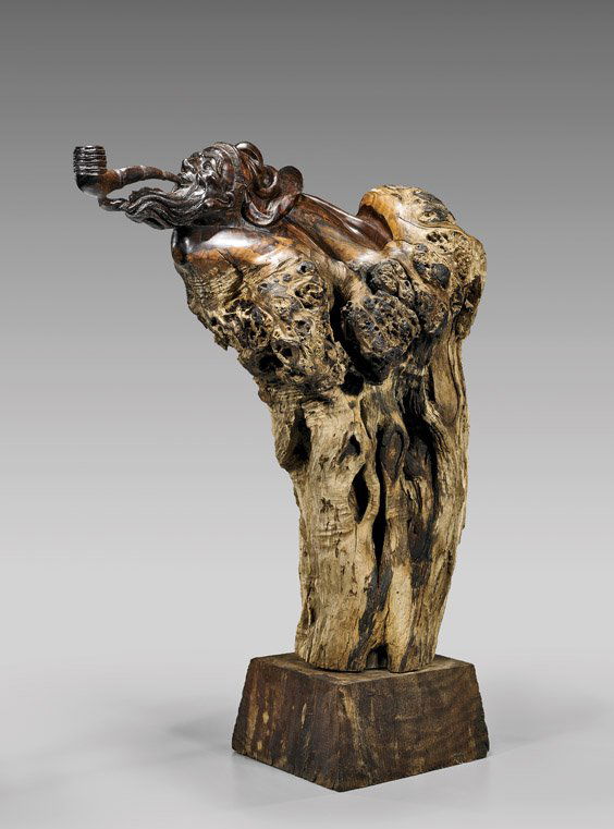 CARVED HUANG HUALI ROOTWOOD SAGE: CARVED HUANG HUALI ROOTWOOD SAGEVery unusual, Chinese huang huali rootwood figure; the upper portion with a finely carved and polished bust of a bearded sage with pipe, seemingly being borne out of th