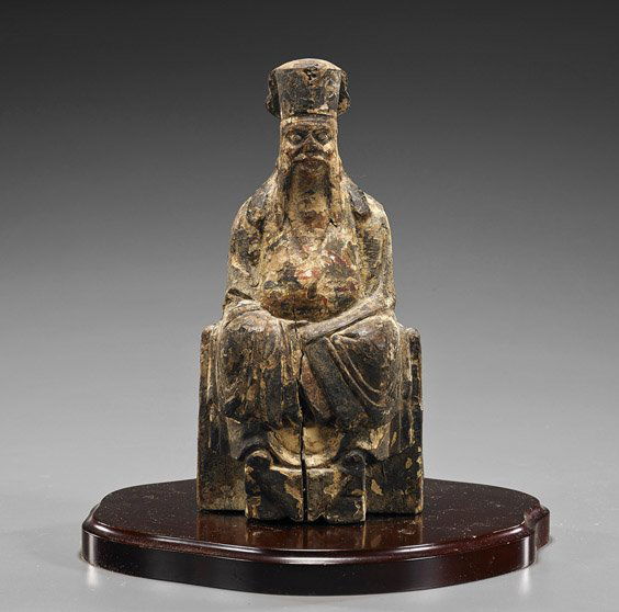 Antique Chinese Carved Wood Temple Figure: Antique Chinese Carved Wood Temple FigureAntique Chinese carved and lacquered wood temple figure; of a bearded man seated in long robes and wearing a tall cap (wear and crack); H: 8 1/2", wood stand