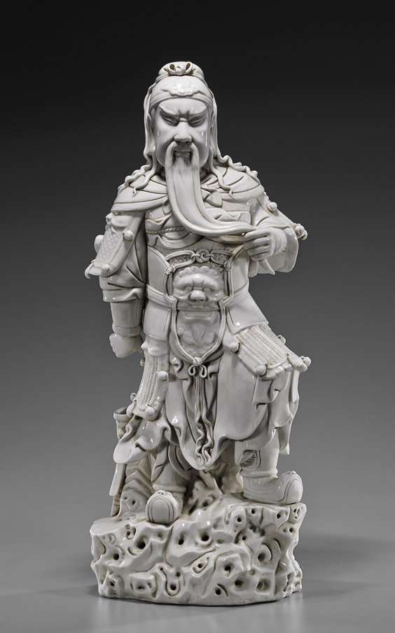 Tall Chinese Blanc de Chinese Porcelain Guandi: Tall Chinese Blanc de Chinese Porcelain Guandi Tall and very elaborately modeled, Chinese blanc de chine porcelain figure of Guandi: standing in full armor atop rockery; gripping his beard in one hand